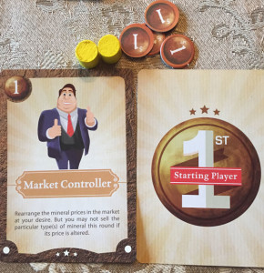 A character card, the starting player card, two yellow workers, and three coins.  