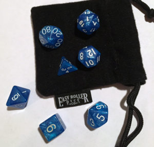 Blue dice of various sides laying on a white surface, a black bag in photo as well