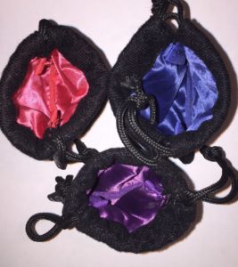 Inside dice bags, aerial shot, black exteriors and blue, purple, red satin interiors