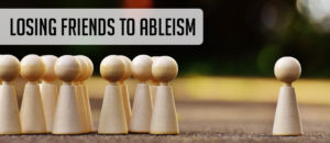 Losing Friends to Ableism. Little wooden meeples, one side they are all grouped up, other side is just one, lonely meeple