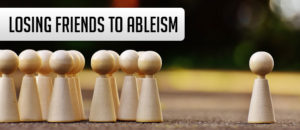 Losing Friends to Ableism. Little wooden meeples, one side they are all grouped up, other side is just one, lonely meeple