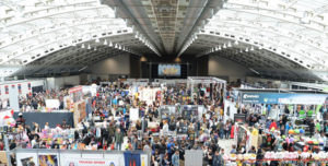 Aerial shot of a convention hall packed with people looking at booths