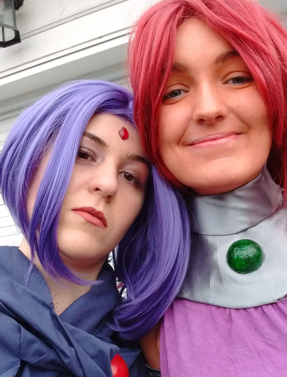 Elaine and her best friend dressed in costume. Elaine wears a purple wig, and dark robe.