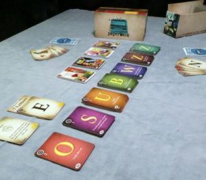 Cards with letters on them in decks, sprawling across the table.