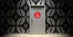 A black and white door with a red universal symbol of disability on it