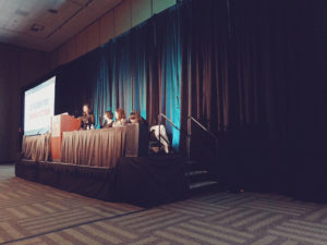side shot of the stage with panelists on top. The only access to the stage is three steps up