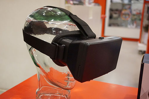 A VR headset atop a clear, plastic head shaped stand